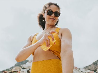 Mulher coloca protetor solar.