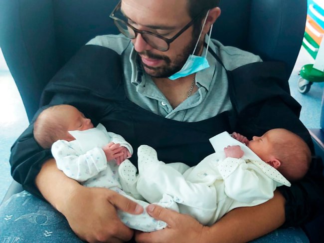 jovem pai com filhas gémeas prematuras ao colo