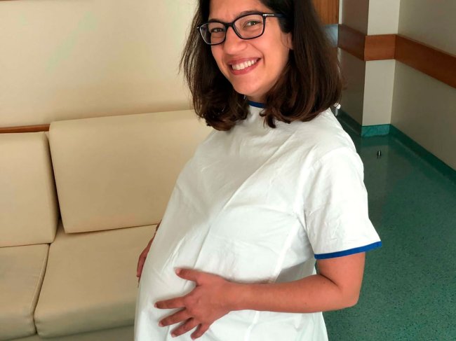 jovem mulher grávida a tocar na barriga