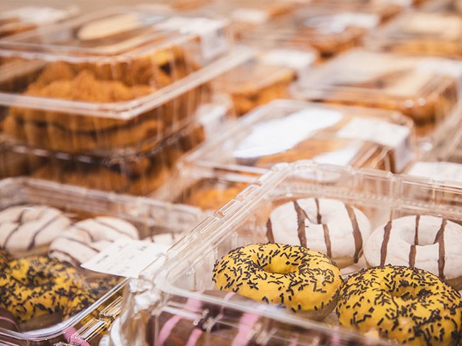 Doces de pastelaria organizados em várias embalagens feitas de plástico.