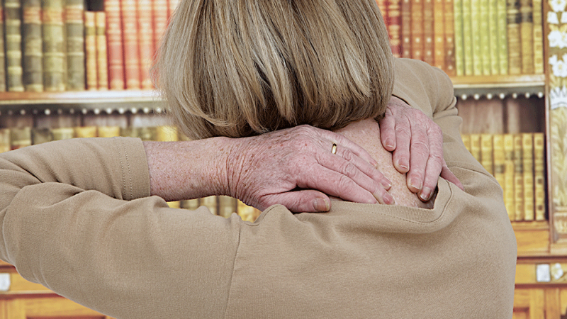 Mulher sente desconforto devido a dor associada a bicos de papagaio