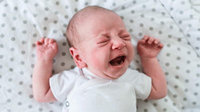 Criança chora devido a cólicas no bebé