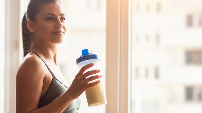 Mulher bebe batido antes de começar a treinar