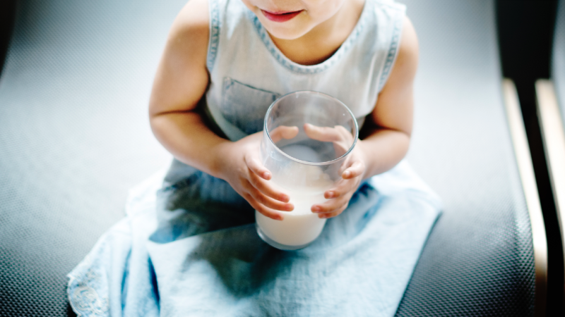 criança com alergias alimentares segura copo de leite