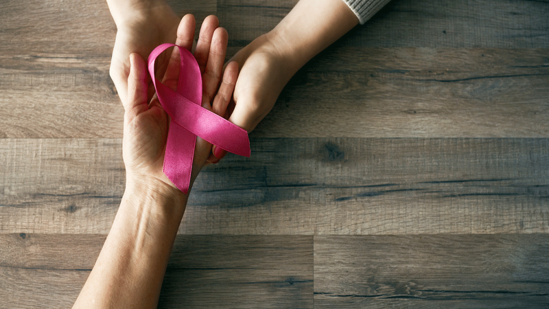 Mulheres seguram laço cor-de-rosa, símbolo do cancro da mama