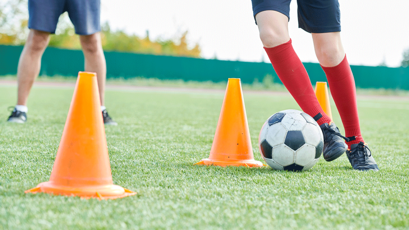 Meninos jogam futebol, havendo um equilíbrio entre desporto e a rotina das crianças