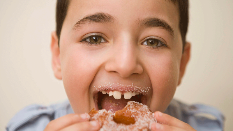 Menino come alimento que pode aumentar risco de diabetes nas crianças