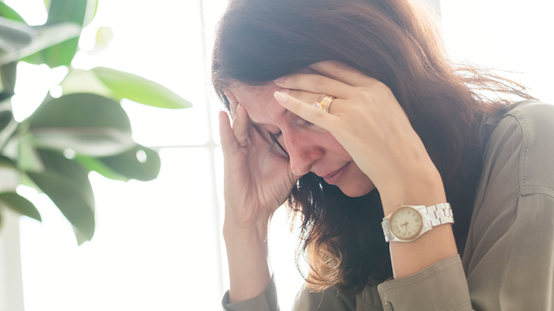 Mulher sofre de sintomas de enxaqueca ou dor de cabeça