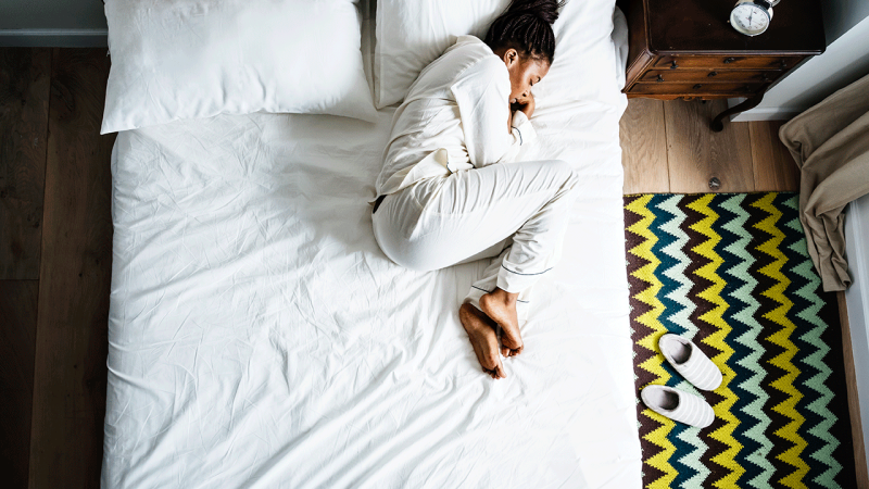 Indivíduo com fadiga descansa na cama