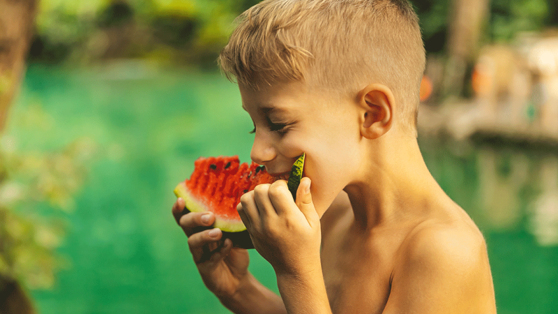Criança come alimento saudável para perder peso de forma saudável