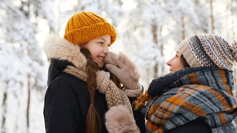 mãe ajuda a filha a proteger-se das doenças de inverno