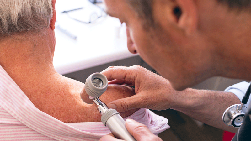 Médico avalia manchas na pele de paciente