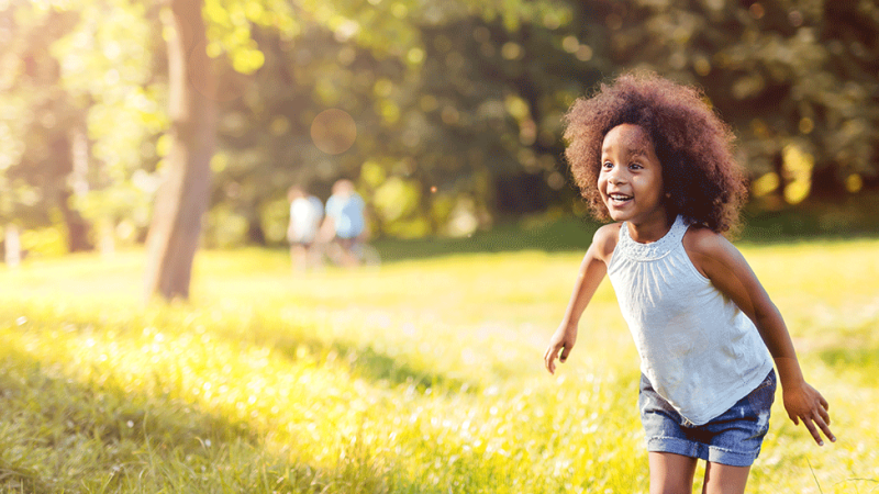 Criança com sinéquia dos pequenos lábios corre no parque