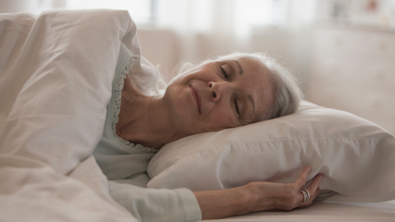 Mulher idosa desfruta de sono na sua cama