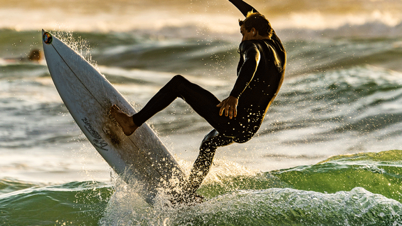 homem a fazer surf de após aprender a prevenir lesões