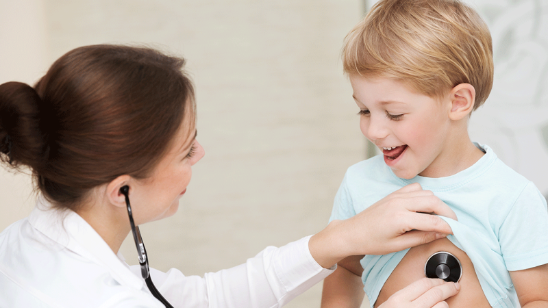Médica ausculta criança para perceber o que significa a dor no coração