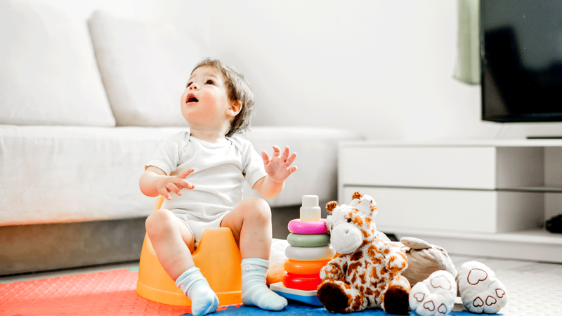 Criança sentada no bacio treina para deixar as fraldas