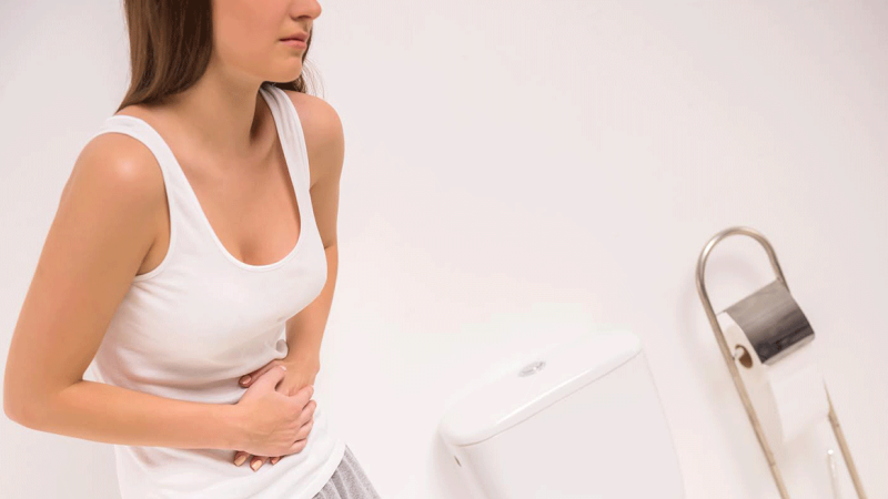 Mulher com dores pondera formas de prevenir as hemorroidas