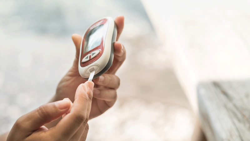 Pessoa mede níveis de glicemia antes de administrar insulina