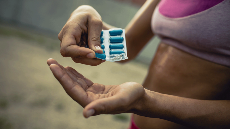 Mulher desportista toma suplementos vitamínicos