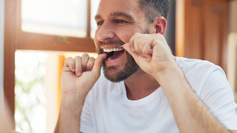 Homem segue recomendações de saúde oral para prevenir COVID-19