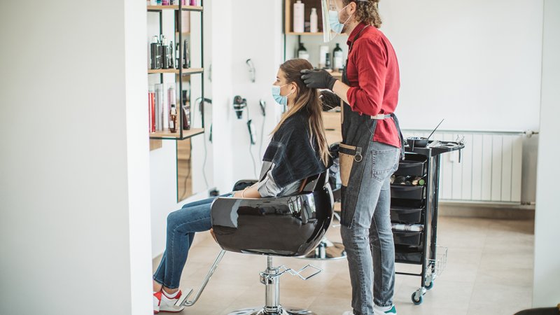 Cliente no cabeleireiro cumpre medidas de prevenção da COVID-19