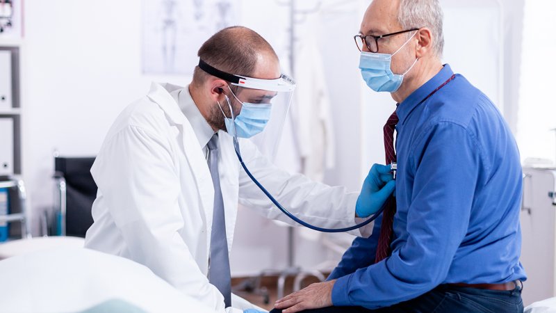 Médico examina doente pós infeção COVID-19