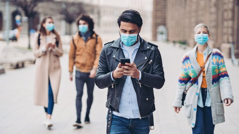 Homem a manter o distanciamento social ao ar livre devido à COVID-19