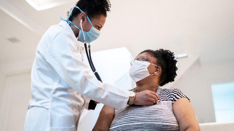 Médica examina mulher para diagnosticar efeitos da COVID-19 no coração