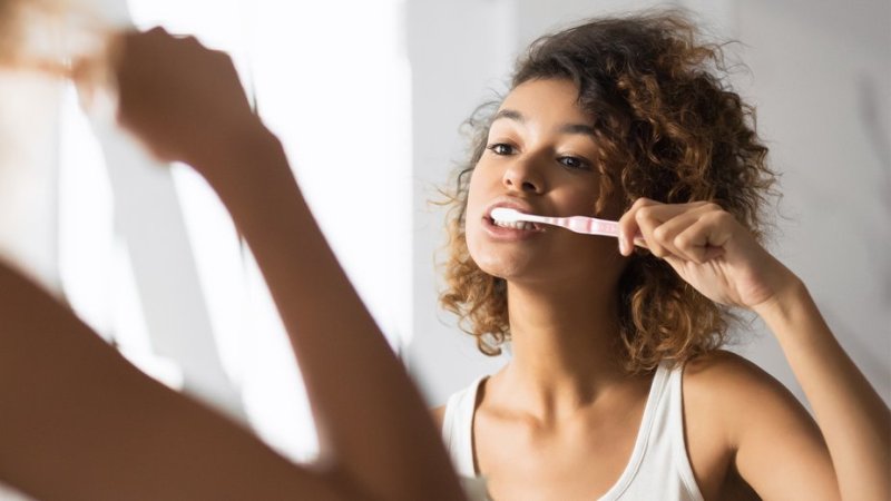 Mulher adota cuidados de higiene oral