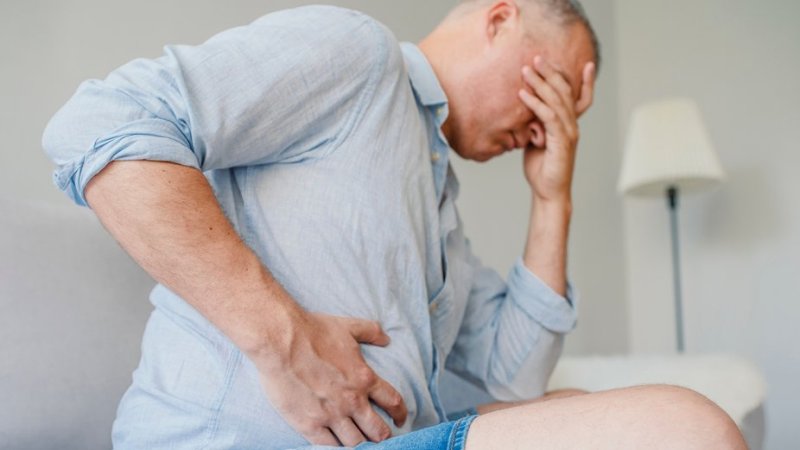 Homem com dor no fígado, causada por hepatite