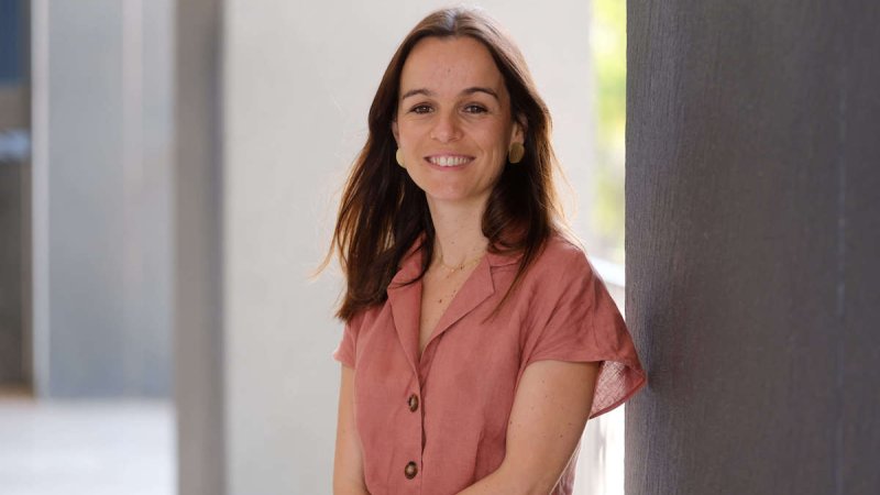 jovem mulher sorridente vestido salmão na rua