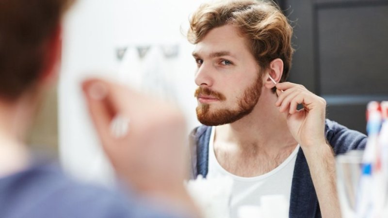 Homem limpa os ouvidos com cotonetes