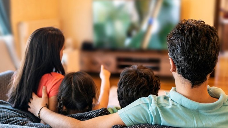 Pais explicam a criança o que está a dar na TV