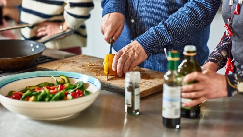 Pessoas preparam refeição saudável para manter pressão arterial controlada