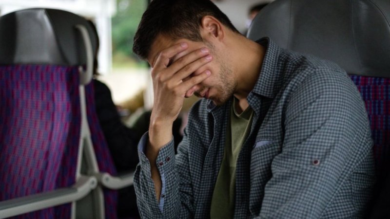 Homem com sintomas de cinetose (ou enjoo por movimento) durante viagem