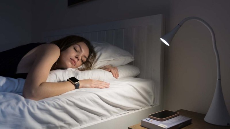 Mulher dorme com relógio para monitorização do sono