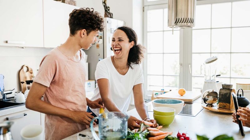 homem e mulher numa cozinha a preparar um snack saudável.