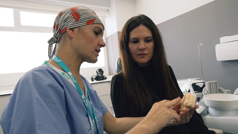 Médica dentista fala com doente sobre reabilitação dentária em 24h