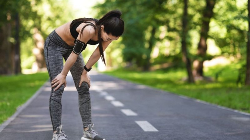 Mulher cansada devido a prática de exercício físico no pós-COVID
