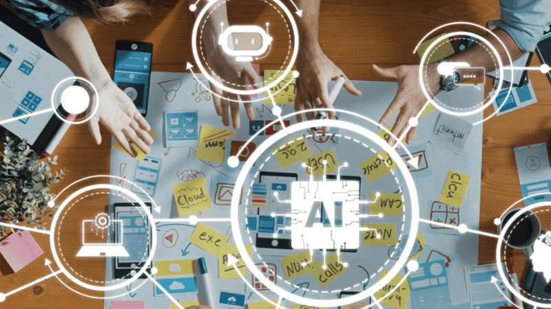 trabalho em equipa numa mesa com ferramentas de Inteligência Artificial