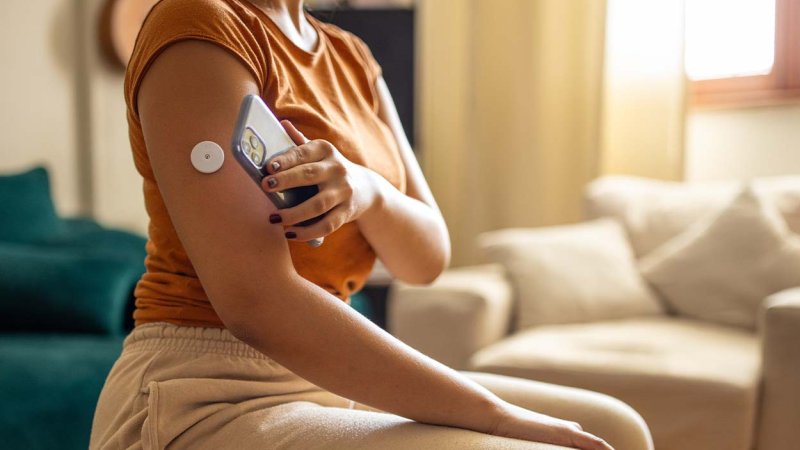 Mulher analisa níveis de glicose no sangue com recurso a dispositivos próprios.