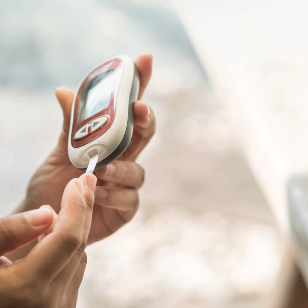 Pessoa mede níveis de glicemia antes de administrar insulina