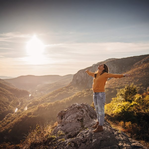 jovem mulher de braços abertos na montanha
