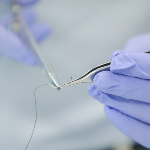 Mãos de médico com pinça 