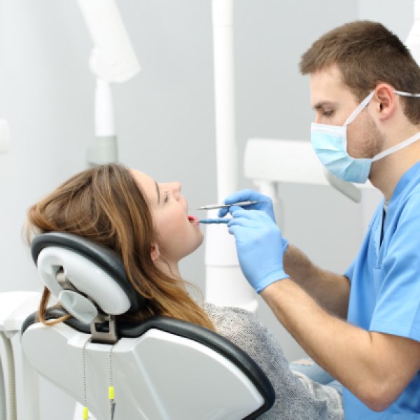 senhora no dentista a fazer rastreio de saúde oral