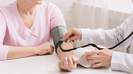 Médico verifica se mulher tem valores ideais de tensão arterial