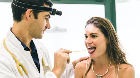 Médico a examinar possíveis doenças da boca