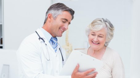 médico mostra relatório a doente sorridente