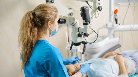 dentista a realizar tratamento de endodontia com microscópio